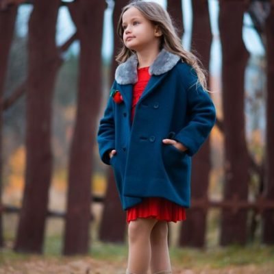beautiful-little-girl-is-wearing-blue-coat-red-dress-shoes-posing-park-looking-away_265562-1116