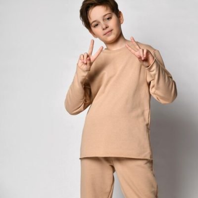 portrait-confident-smiling-preteen-boy-showing-vsign-raising-two-hands-gesture-victory-peace-cute-caucasian-child-beige-sportswear-enjoying-winning-standing-studio-background_417694-807